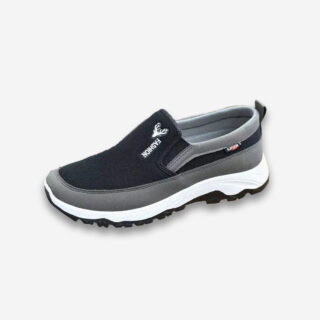 Une basket orthopédique homme décontractée de couleur noire, grise et blanche, sans lacet, sur un fond gris très clair uni.