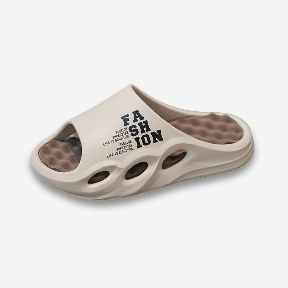Une claquette orthopédique homme fashion à semelle massante en mousse dans des tons beiges sur un fond gris très clair uni.