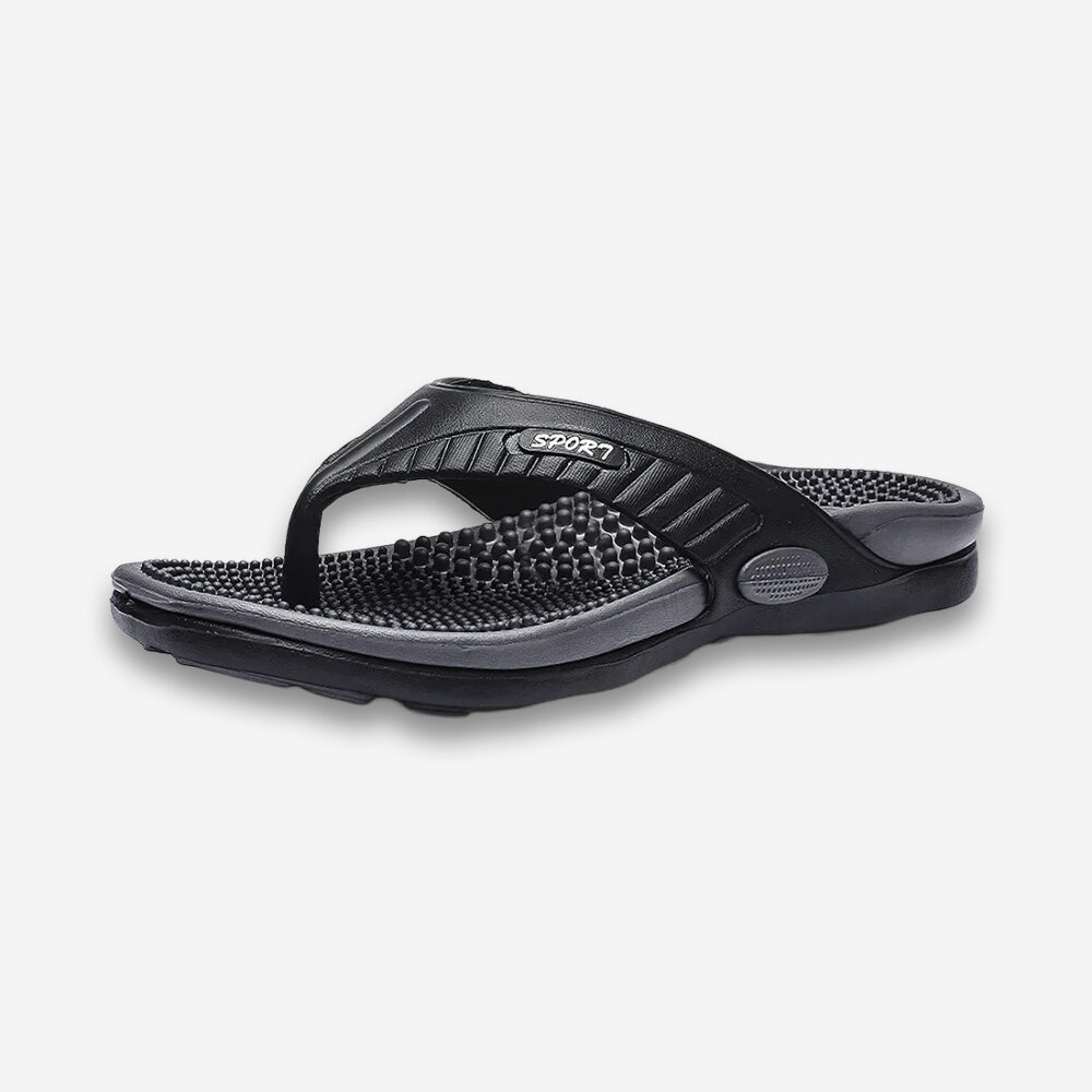 Une tong orthopédique pour homme à semelle massante de couleur noire sur un fond gris très clair uni.