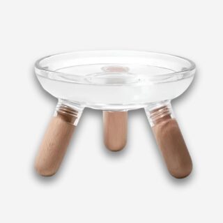 Bol orthopédique pour chat avec coupelle transparente. 3 pieds de couleur bois clair. Sur fond uni clair.