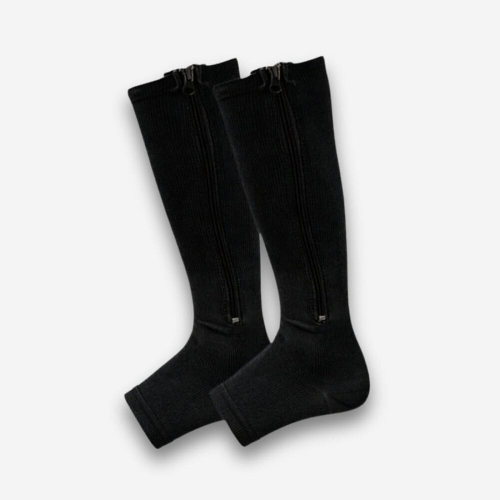 Chaussettes orthopédiques à fermeture éclair de couleur noire avec le bout aux orteils ouverts. Sur fond uni clair.