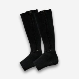 Chaussettes orthopédiques à fermeture éclair de couleur noire avec le bout aux orteils ouverts. Sur fond uni clair.