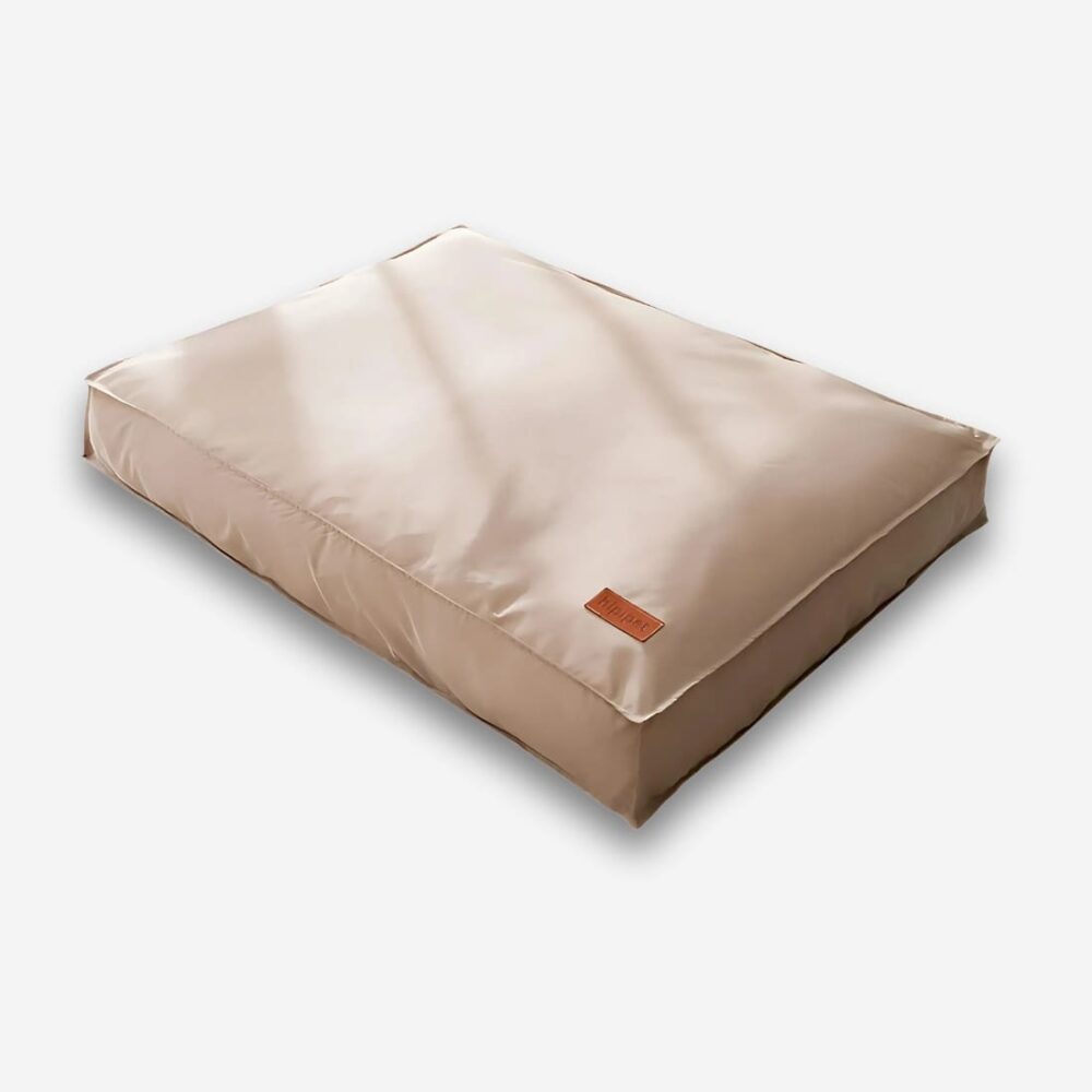 Coussin orthopédique pour chien épais de forme rectangulaire et de couleur marron. Sur fond uni clair.