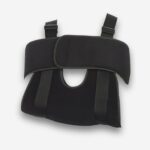 Gilet orthopédique immobilisation de l'épaule de couleur noire avec une sangle pectorale et un espace pour glisser le bras. Sur fond uni clair.