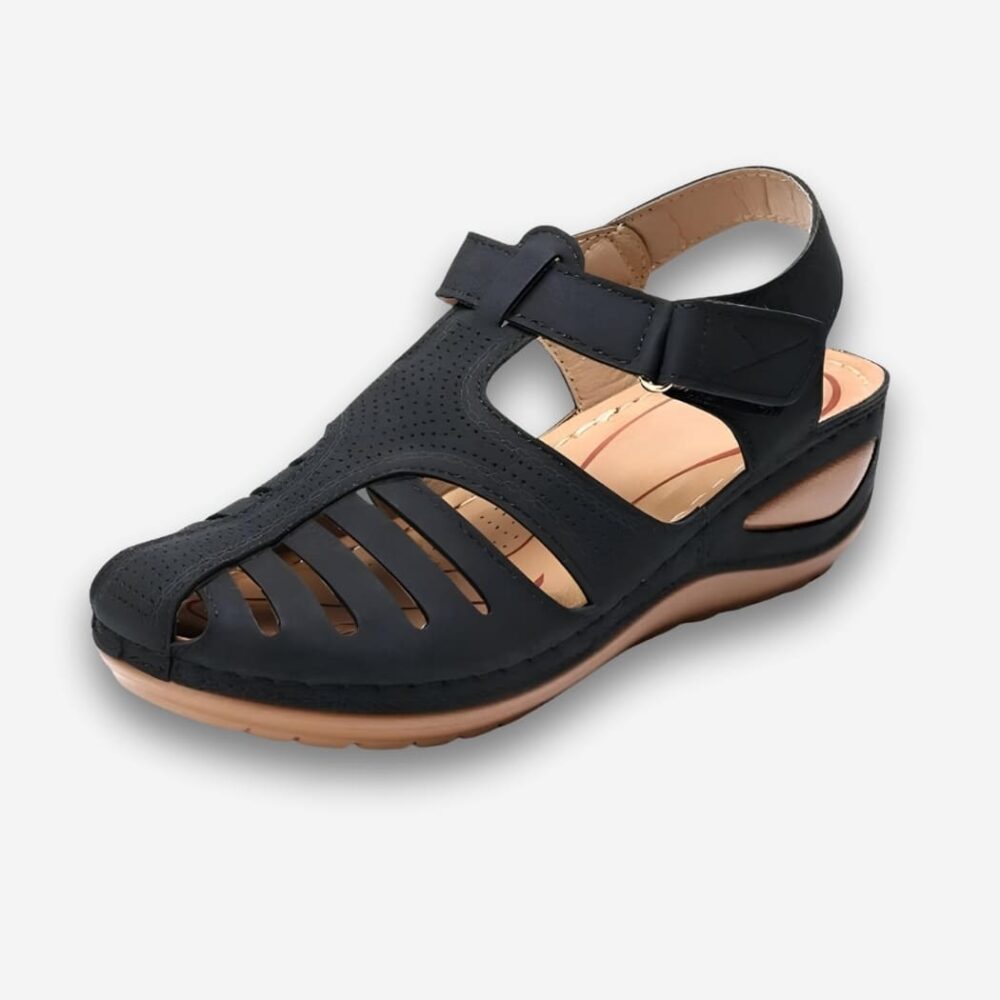 Sandales orthopédiques antidérapantes pour femme de couleur noires avec une semelle épaisse au talon sur fond uni clair.