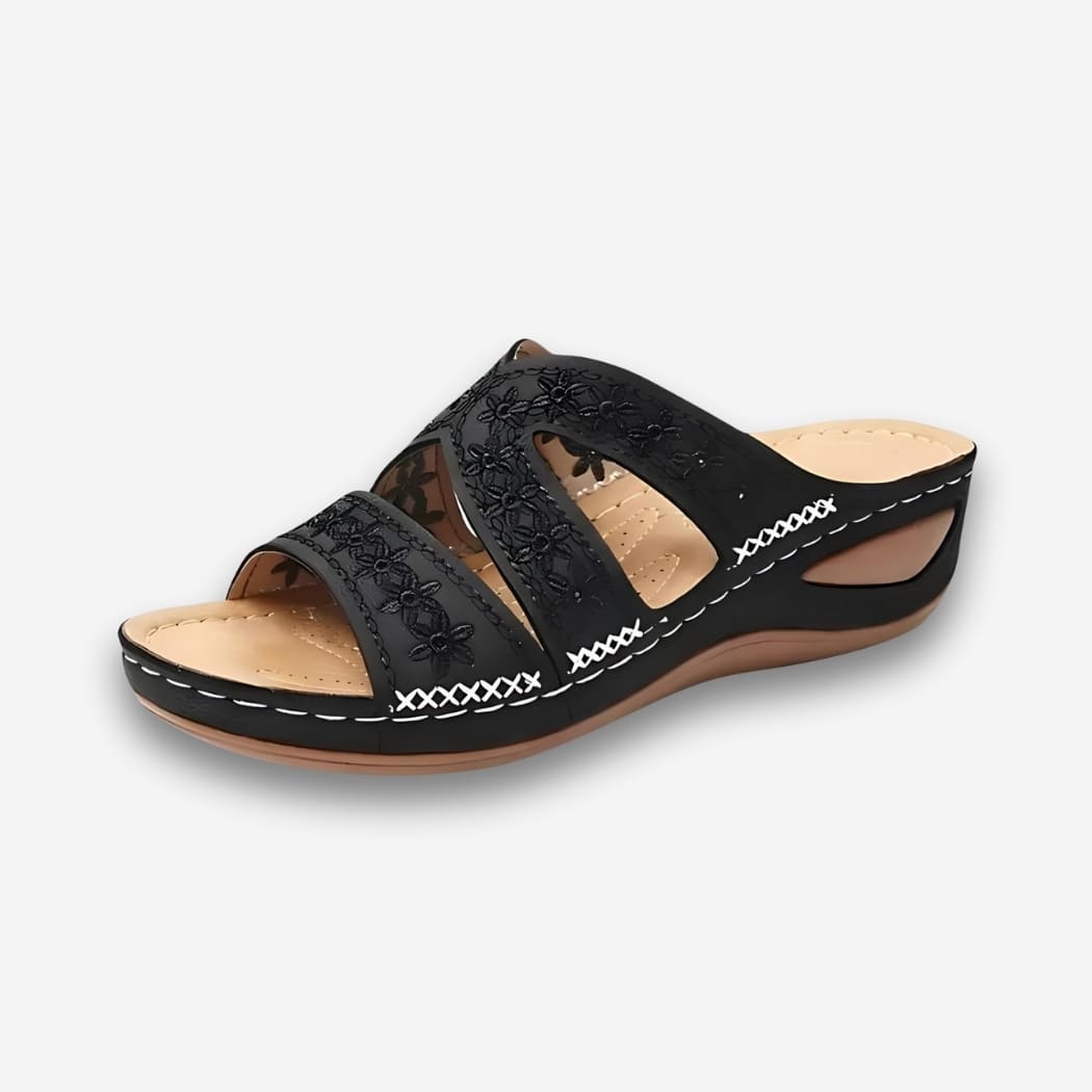 Sandales orthopédiques vintage pour femme noire avec talon compensé sur fond uni clair.
