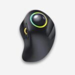 Souris orthopédique sans fil rétro-éclairée avec trackball. De couleur noire, une molette sur la gauche et un cercle coloré autour de la trackball. Sur fond uni clair.