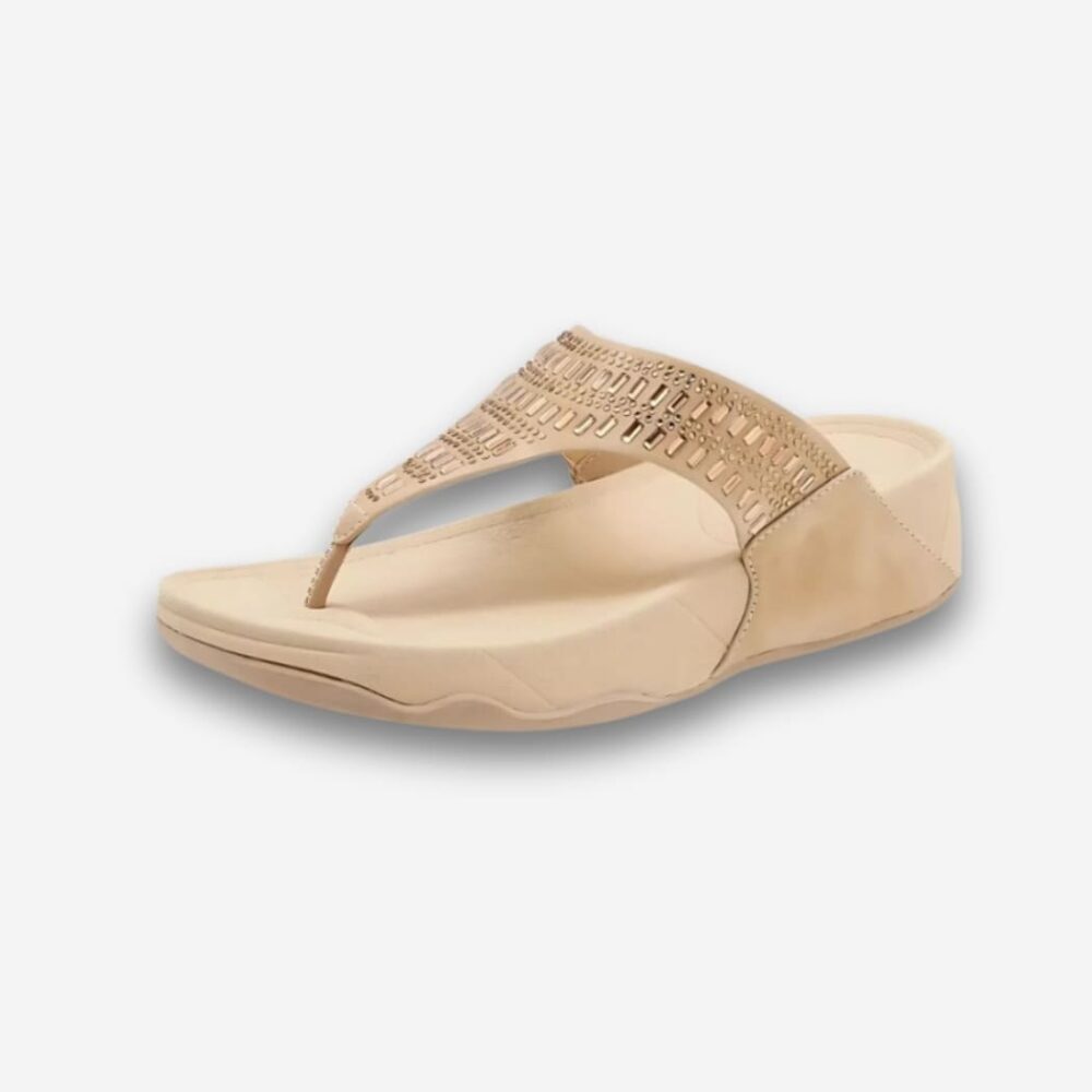 Tongs orthopédiques compensées pour femme de couleur beige avec des détails brillants sur la bride. Sur fond uni clair.