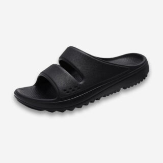 Une claquette orthopédique pour homme super souple en mousse et à semelle crantée, de couleur noire, disposée sur un fond gris très clair uni.
