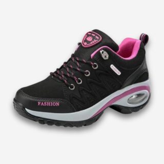 Baskets orthopédiques de marche ou randonnée pour femme de couleur noire avec détails roses. Sur fond uni clair.