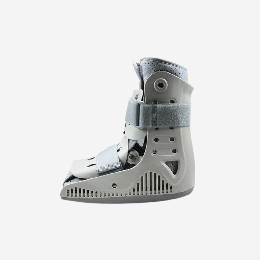 Botte orthopédique courte avec coque rigide grise et sangles ajustables, vue de côté, sur fond neutre.