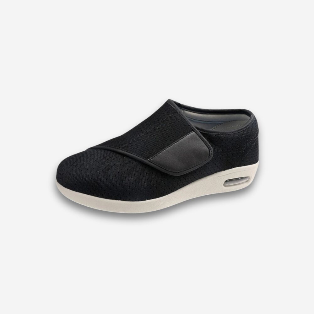 Chaussure orthopédique noire pour homme, vue de côté, semelle blanche avec coussin d'air, sur fond neutre.