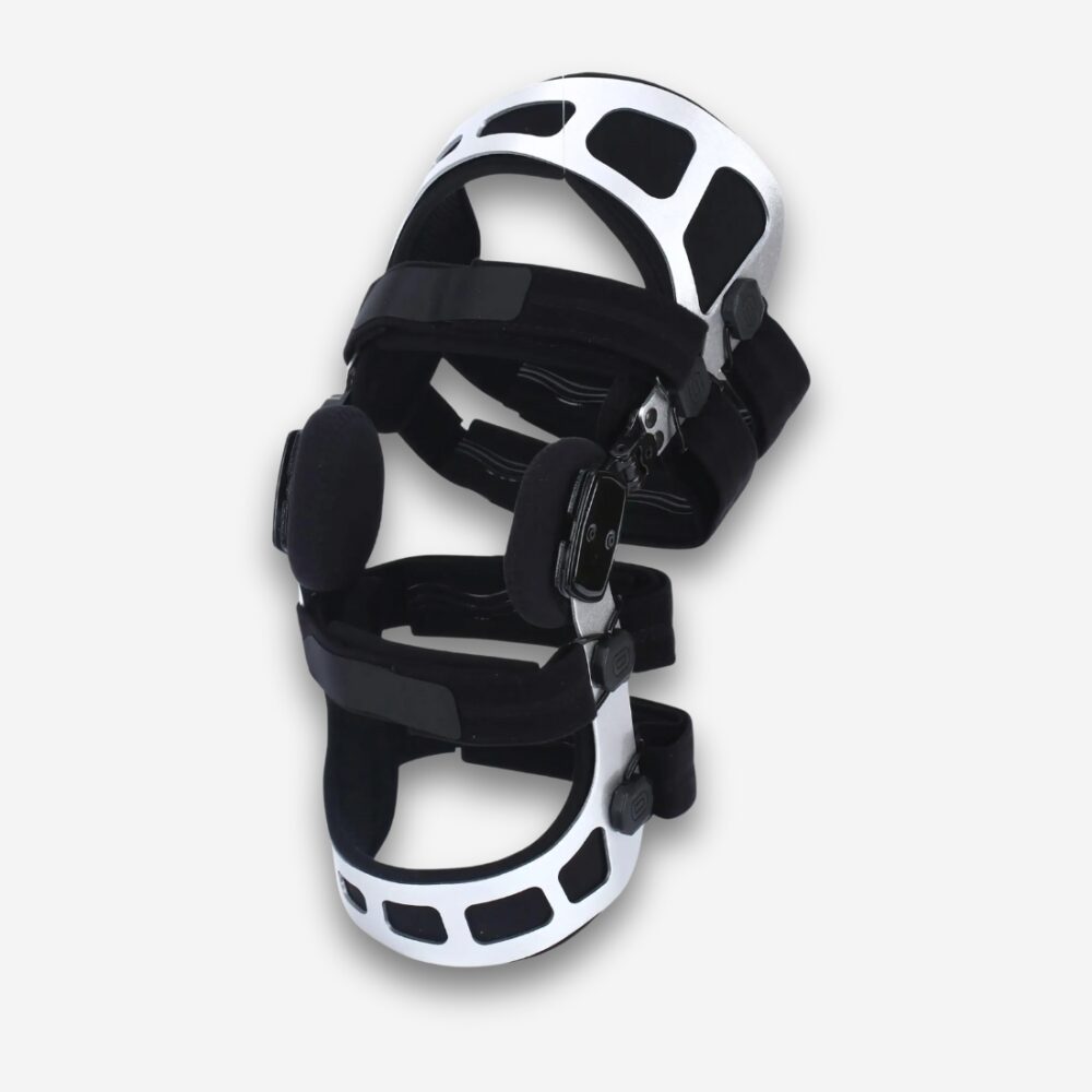 Prothèse orthopédique pour genou, avec armature articulée et sangles de maintien, sur fond neutre.