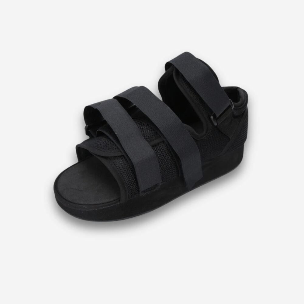 Chaussure orthopédique noire ouverte avec brides de maintien, vue 3/4, sur fond neutre.