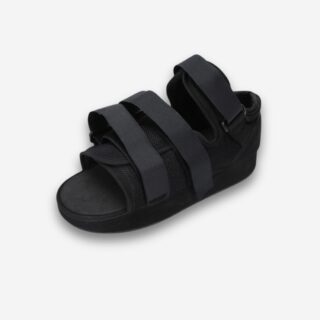Chaussure orthopédique noire ouverte avec brides de maintien, vue 3/4, sur fond neutre.