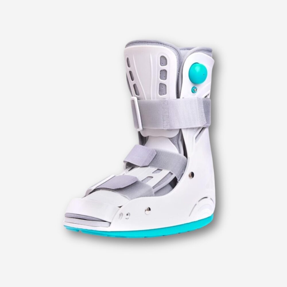 Botte orthopédique blanche avec sangles grises, semelle large bleu turquoise et coque rigide blanche, vue de 3/4, présentée sur fond neutre.