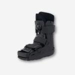 Botte orthopédique noire courte avec coque rigide et sangles, vue de profil sur fond neutre.