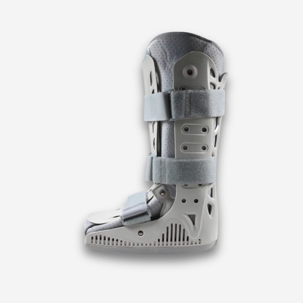 Botte orthopédique à tige haute grise avec semelle large et sangles de maintien, vue de profil sur fond neutre.