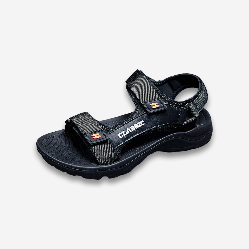 Une sandale orthopédique homme antidérapante noire en toile et caoutchouc, sur un fond gris très clair uni.