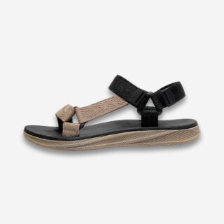Une sandale orthopédique homme décontractée à semelle épaisse et support de voûte plantaire, de couleur noire et beige, de profil sur un fond gris très clair uni.