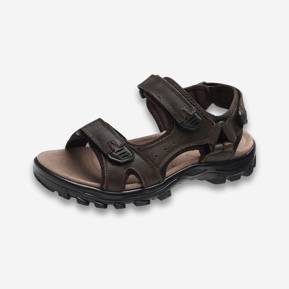 Une sandale orthopédique homme pour randonnée de couleur marron, à semelle antidérapante noire, sur un fond gris très clair uni.