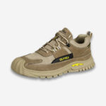 Une chaussure de sécurité orthopédique khaki basses présentant sa semelle renforcée sur un fond gris très clair uni.