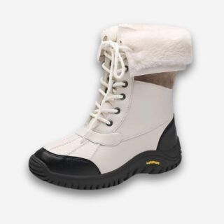 Bottes orthopédiques antidérapantes pour femme de couleur blanche avec fourrure à l'intérieur. La semelle est noire. Sur fond uni clair.