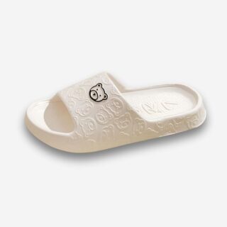Claquettes orthopédiques en EVA épaisses et confortables de couleur blanche avec un motif d'ours noir. Sur fond uni clair.