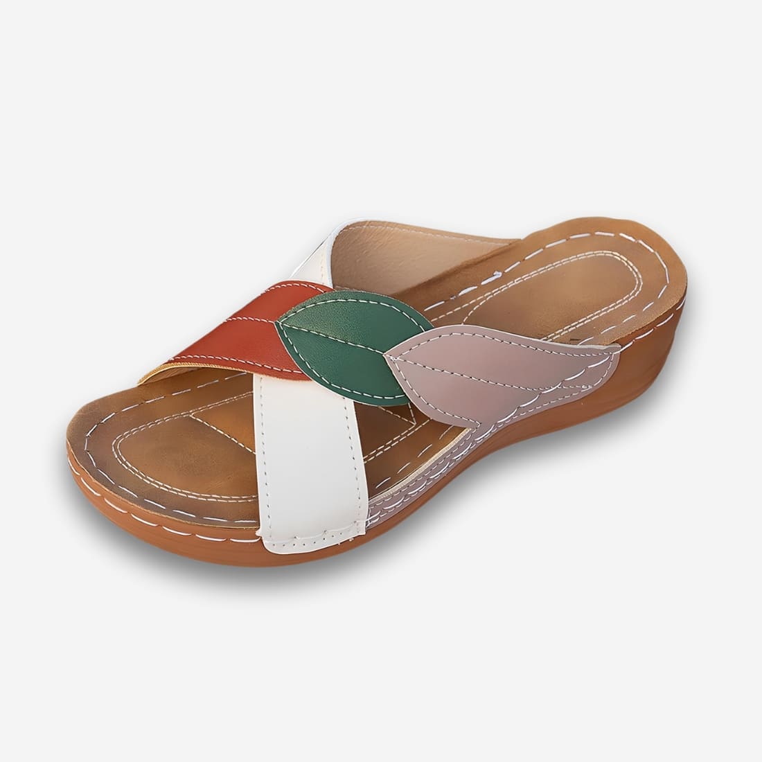 Mules orthopédiques pour femme au design estival en cuir synthétique avec semelle compensée et deux brides qui se croisent sur le dessus du pied, une blanche et l'autre terracotta, verte et beige. Sur fond gris très clair.