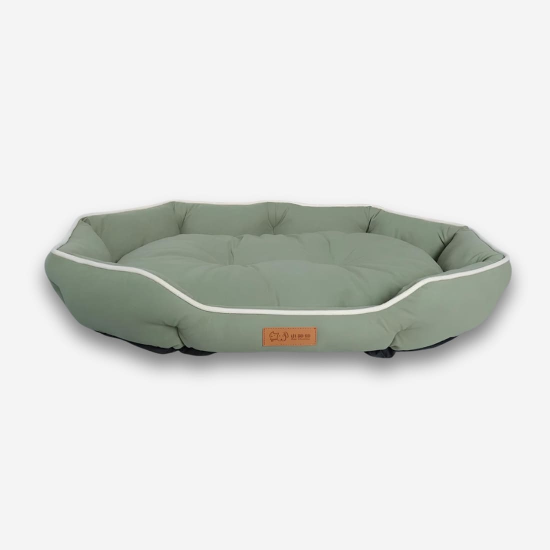 Panier orthopédique pour chien en coton de couleur verte et de forme ovale rembourré. Sur fond uni clair.