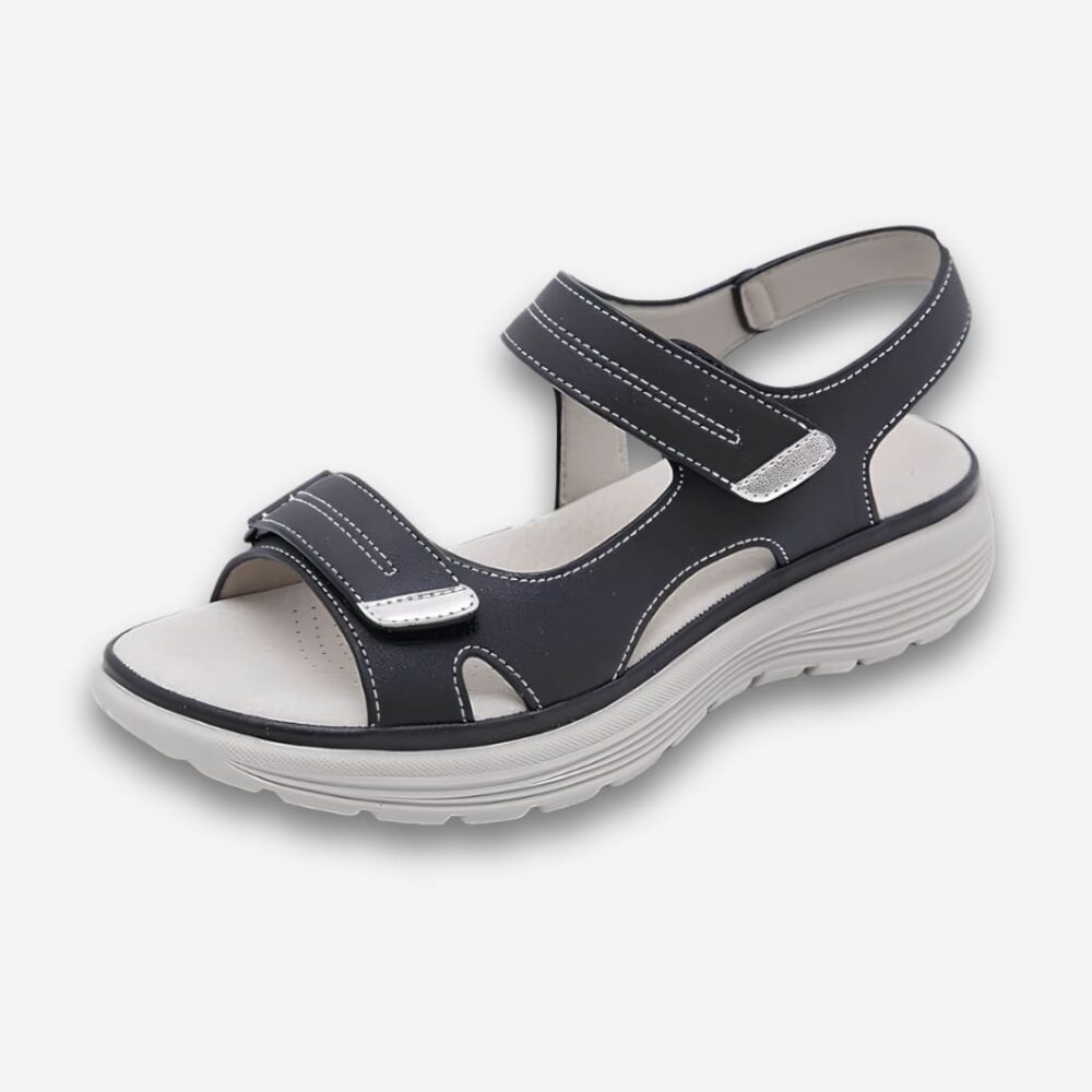 Sandales orthopédiques semelle compensée antidérapante de couleur noire avec une semelle blanche. Deux brides de maintien. Sur fond uni clair.