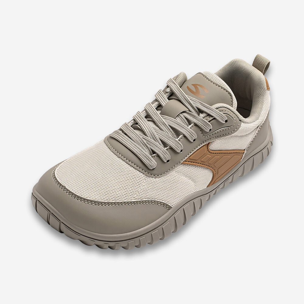 Une basket orthopédique homme à bout large de couleur beige avec trois nuances de teinte, vue de 3/4 sur un fond gris très clair uni.