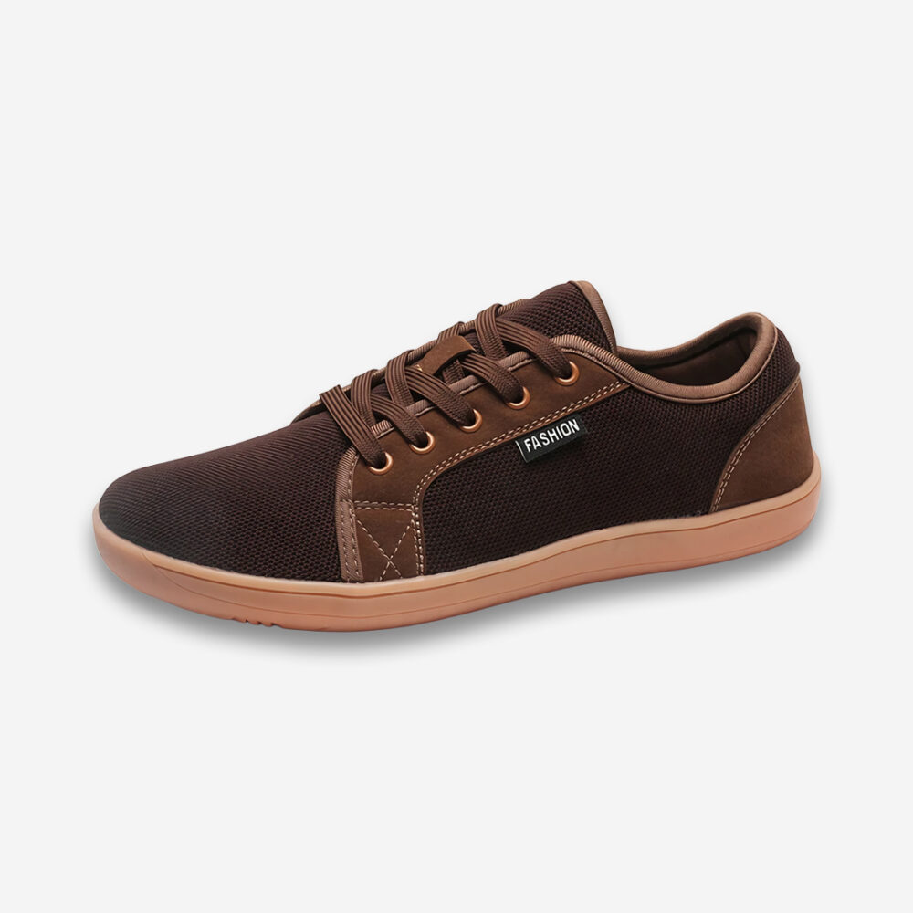 Une chaussure orthopédique homme large décontractée dans des tons marrons, avec des lacets, vue de profil sur un fond gris très clair uni.