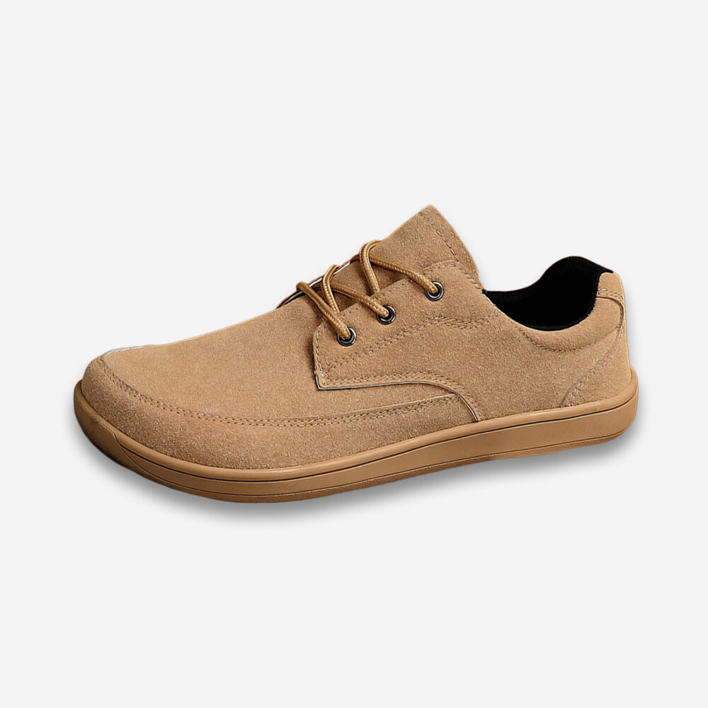 Une chaussure orthopédique homme large minimaliste de couleur beige, vu de profil sur un fond gris très clair uni.