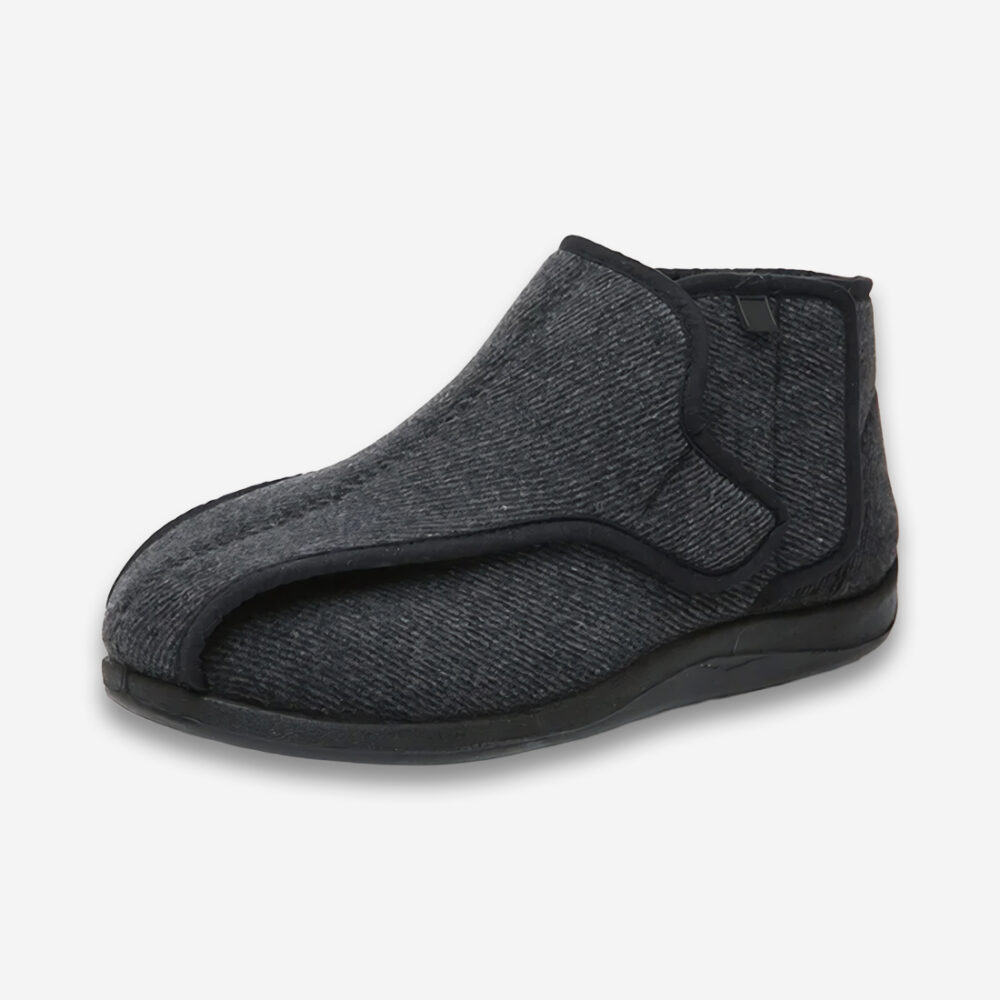 Un chaussons orthopédique homme pour l'hiver de couleur noire, montant jusqu'en haut de la cheville avec une fermeture à scratch, sur un fond gris très clair uni.