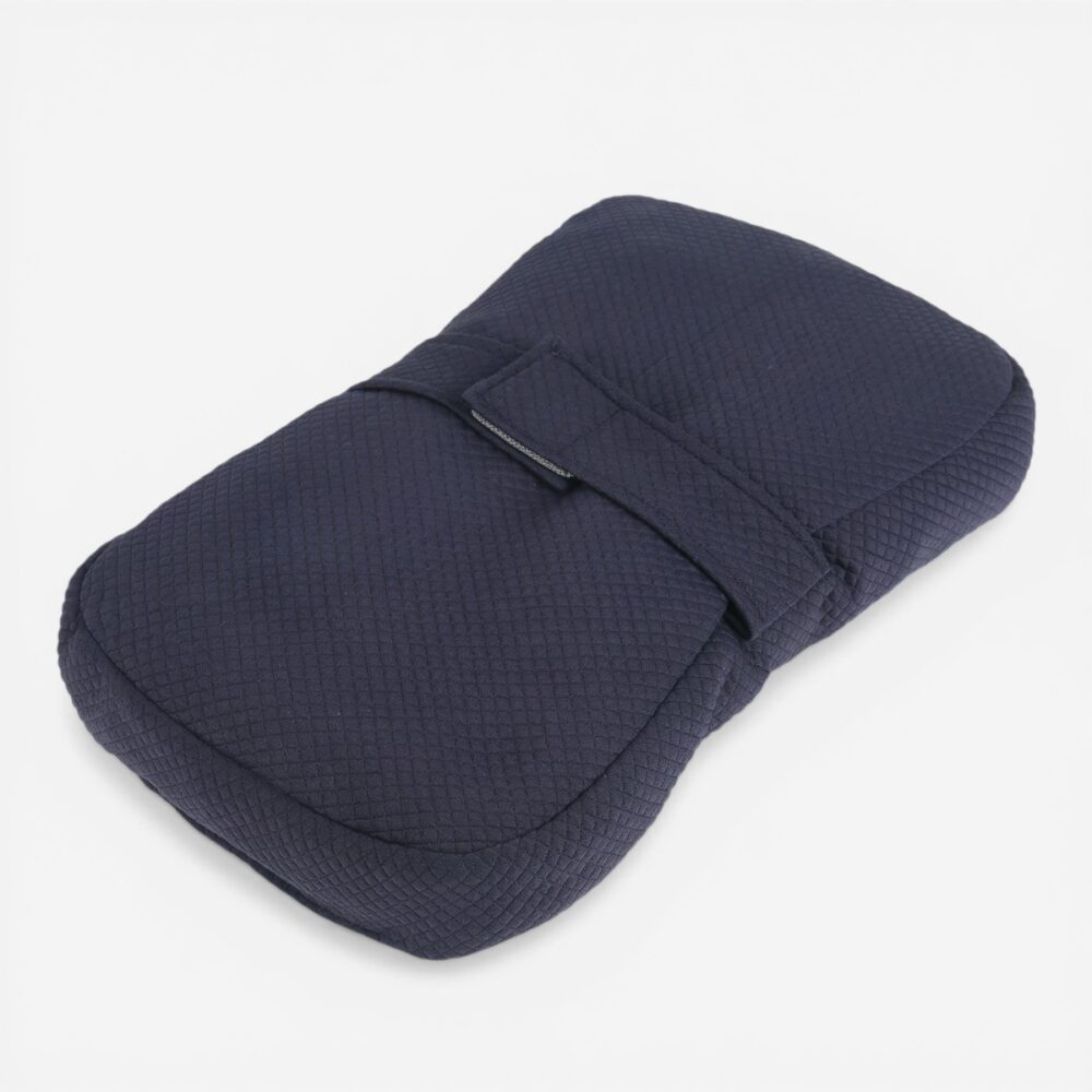 Le coussin orthopédique position latéral pour genoux bleu marine, un tissu de qualité en forme de losange, doté d'une sangle velcro plate centrale, vue 3/4 fond gris.